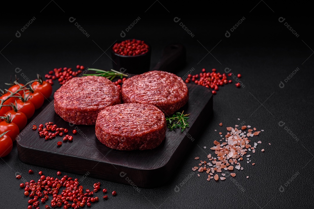 Hambúrguer de carne moída crua fresca com sal e especiarias em fundo de concreto texturizado
