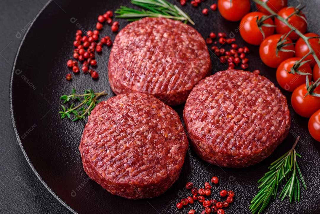 Hambúrguer de carne moída crua fresca com sal e especiarias em fundo de concreto texturizado