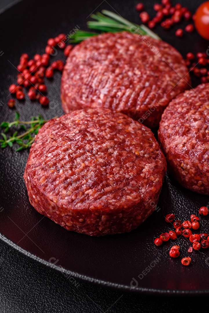 Hambúrguer de carne moída crua fresca com sal e especiarias em fundo de concreto texturizado