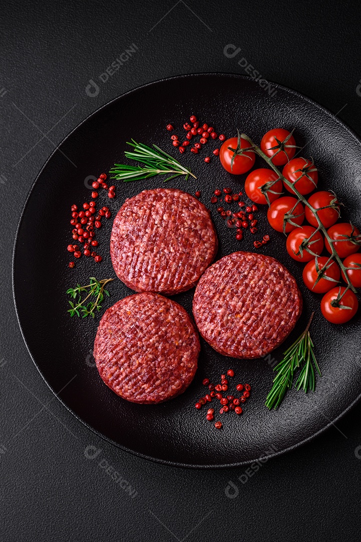 Hambúrguer de carne moída crua fresca com sal e especiarias em fundo de concreto texturizado
