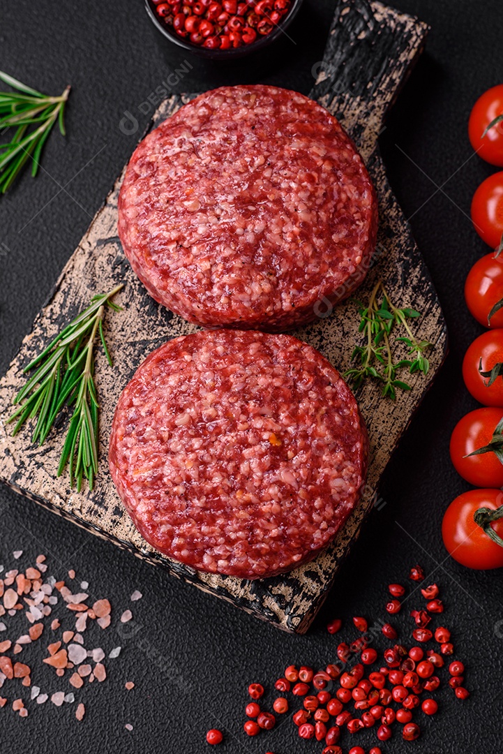 Hambúrguer de carne moída crua fresca com sal e especiarias em fundo de concreto texturizado