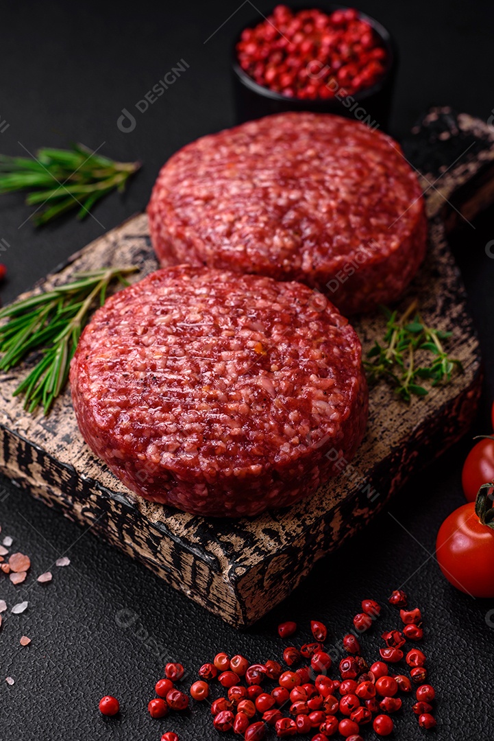 Hambúrguer de carne moída crua fresca com sal e especiarias em fundo de concreto texturizado