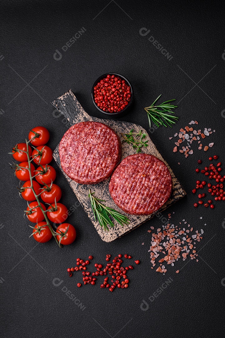 Hambúrguer de carne moída crua fresca com sal e especiarias em fundo de concreto texturizado