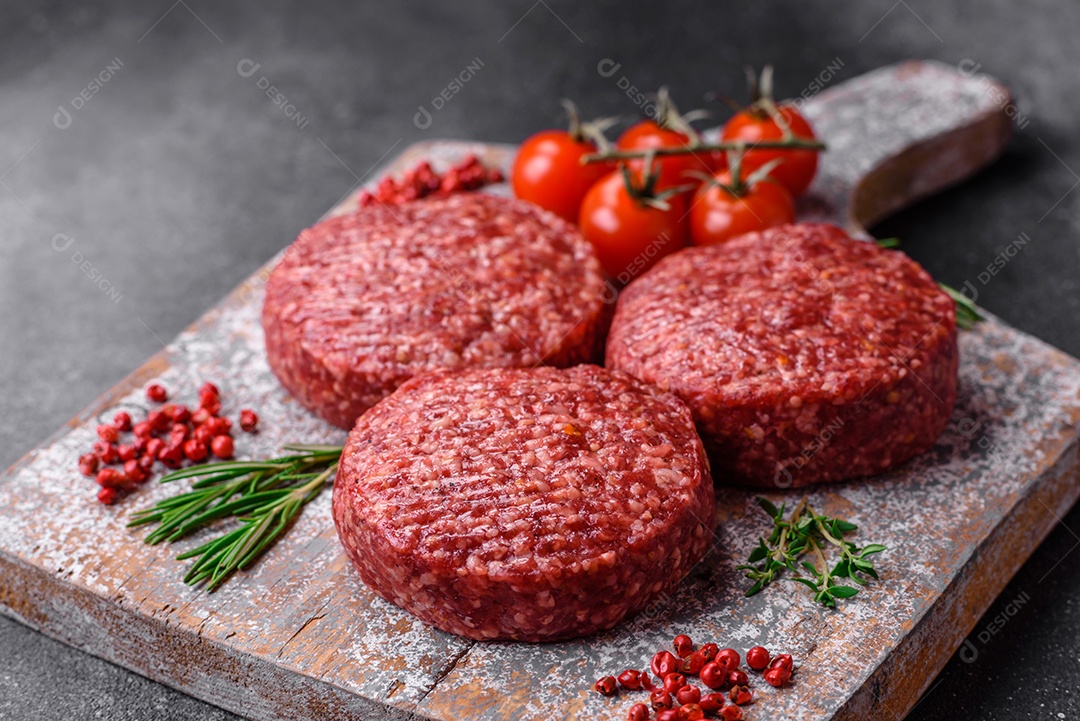 Hambúrguer de carne moída crua fresca com sal e especiarias em fundo de concreto texturizado