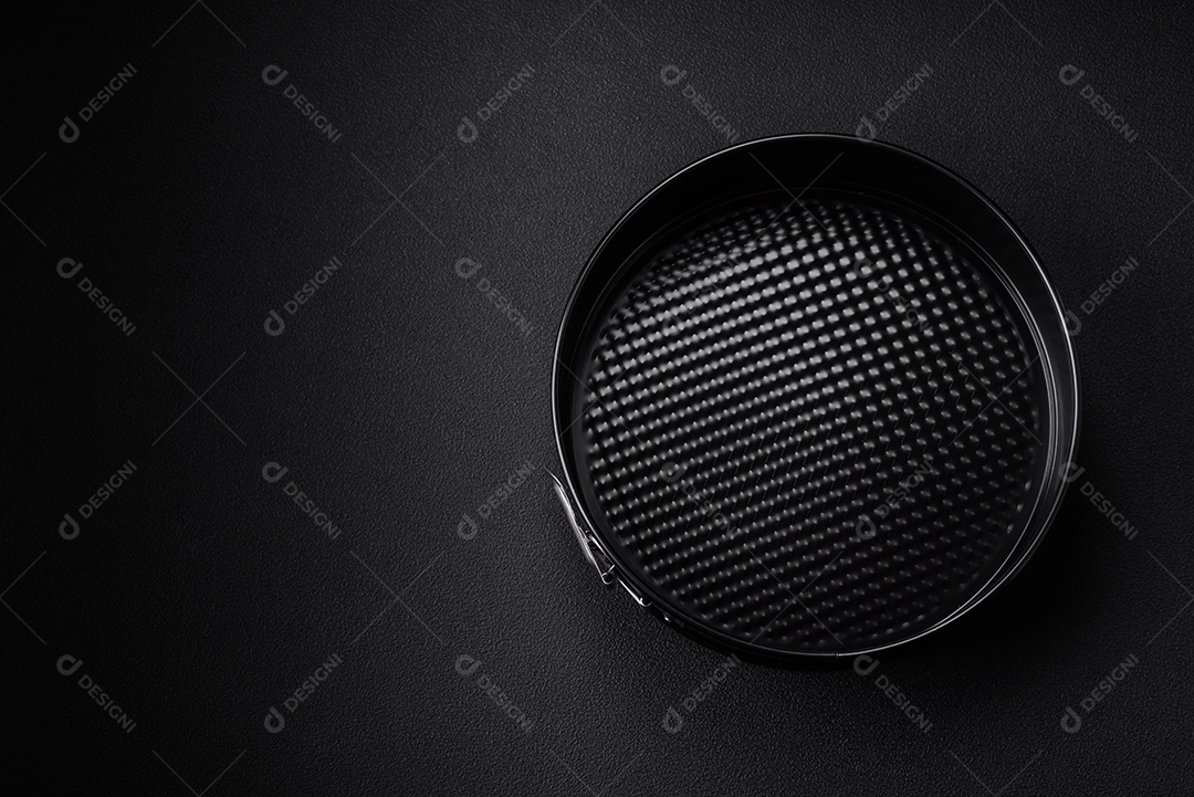 Assadeira destacável preta de metal redondo para assar em um fundo escuro de concreto
