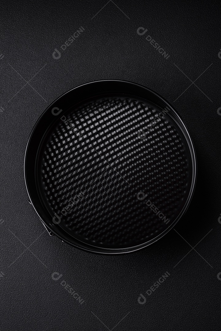 Assadeira destacável preta de metal redondo para assar em um fundo escuro de concreto