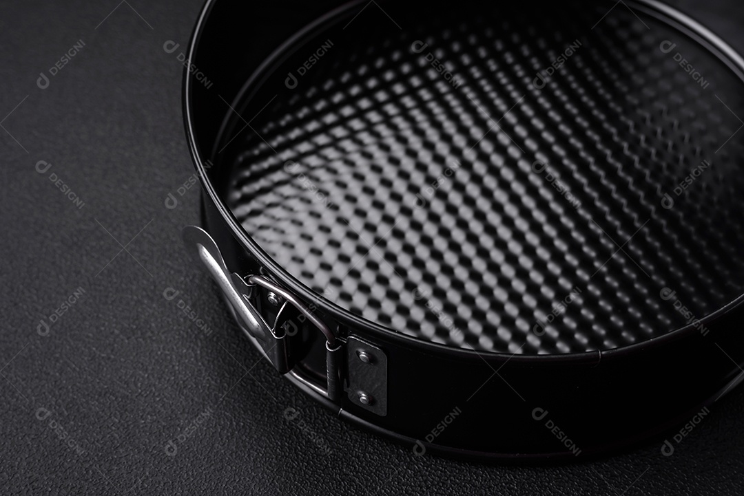 Assadeira destacável preta de metal redondo para assar em um fundo escuro de concreto