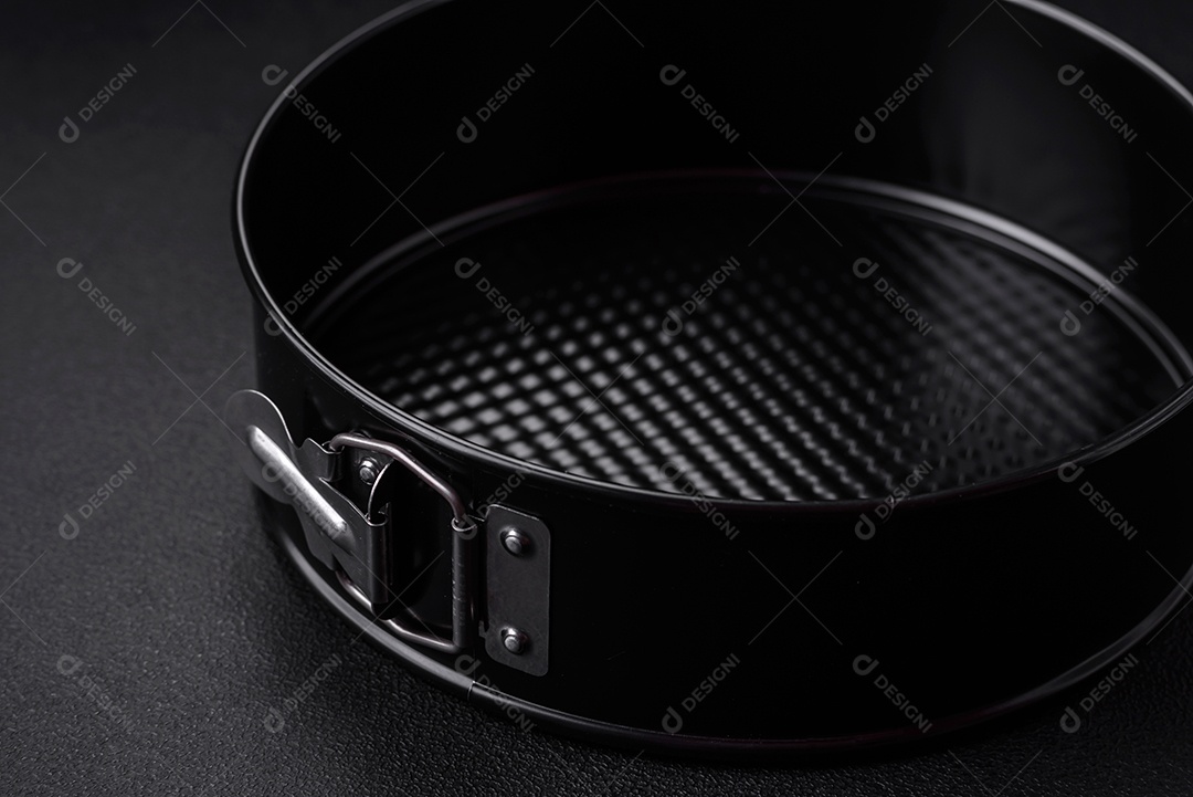 Assadeira destacável preta de metal redondo para assar em um fundo escuro de concreto