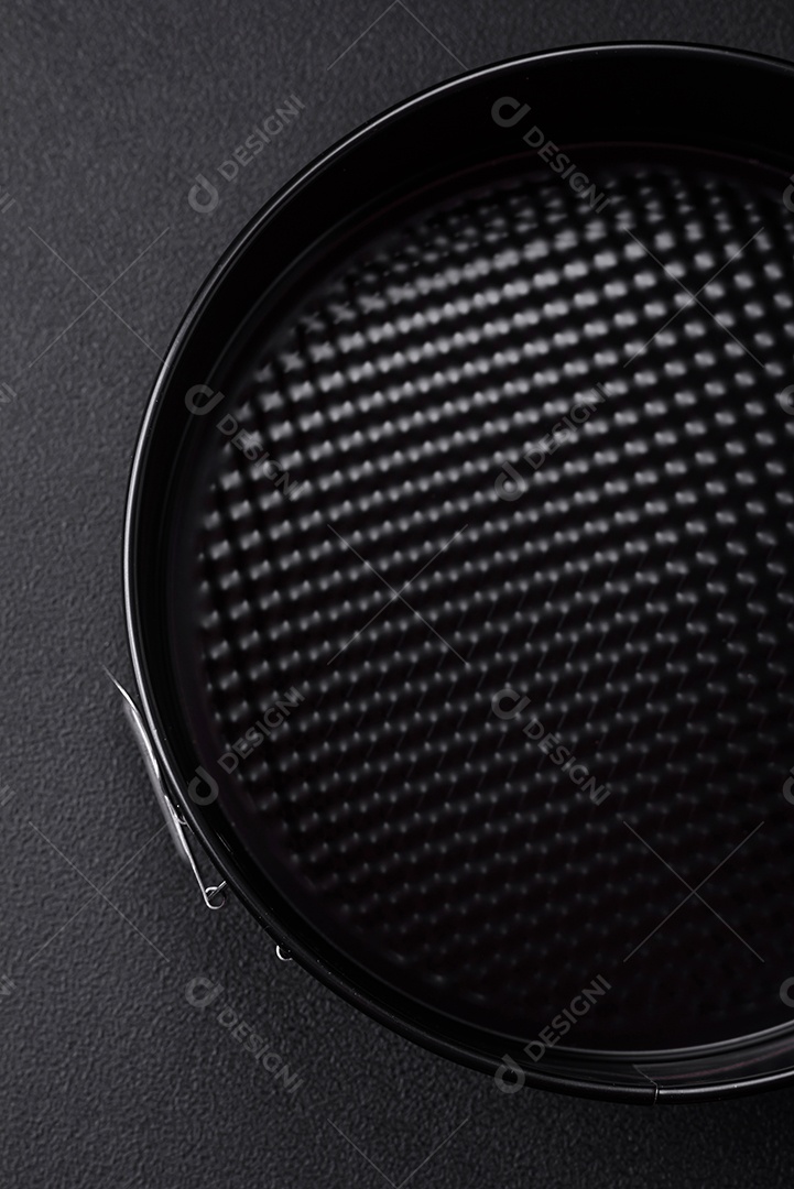 Assadeira destacável preta de metal redondo para assar em um fundo escuro de concreto