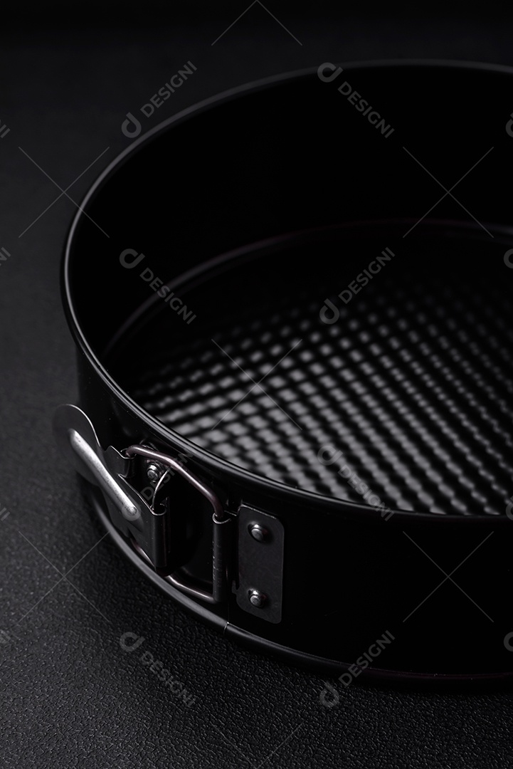 Assadeira destacável preta de metal redondo para assar em um fundo escuro de concreto