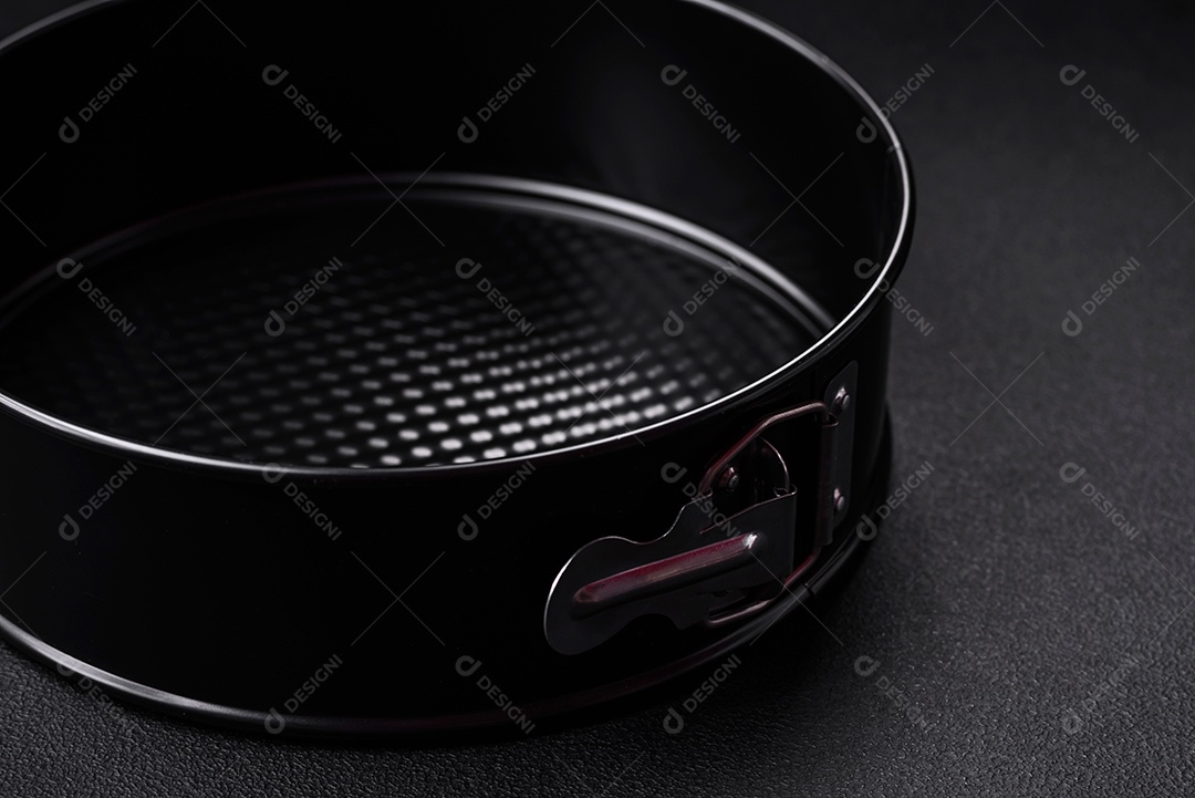 Assadeira destacável preta de metal redondo para assar em um fundo escuro de concreto