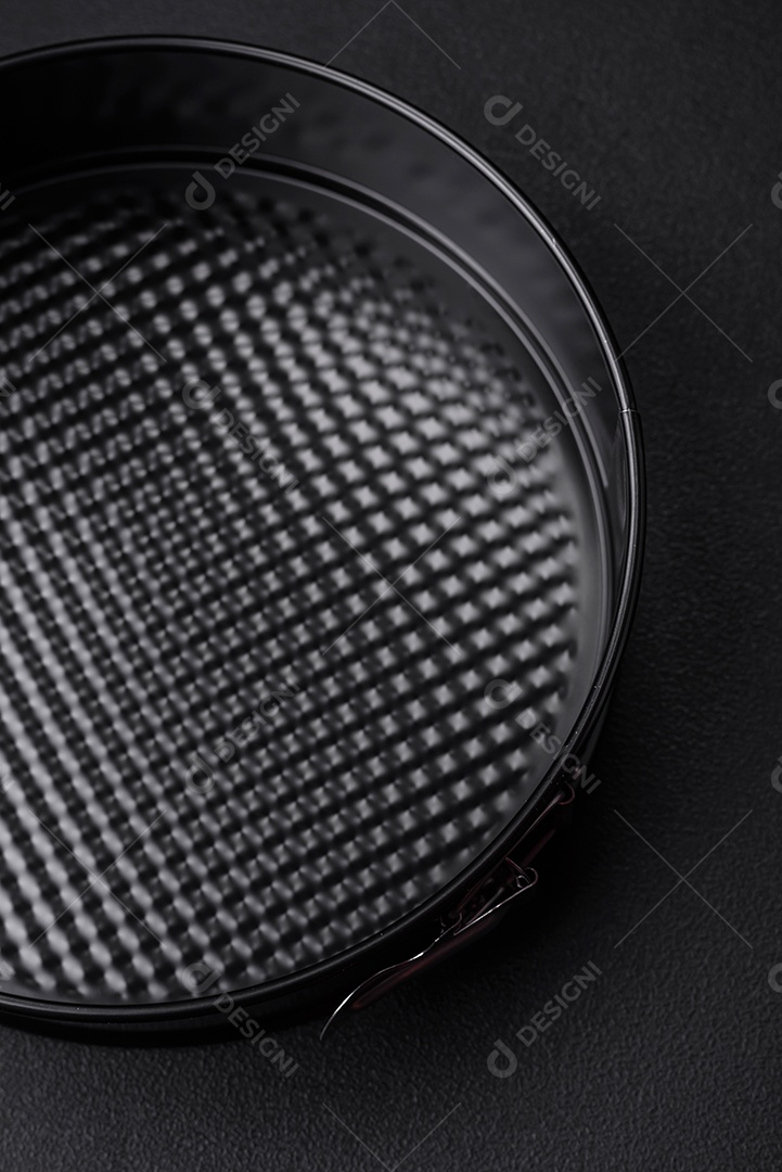 Assadeira destacável preta de metal redondo para assar em um fundo escuro de concreto
