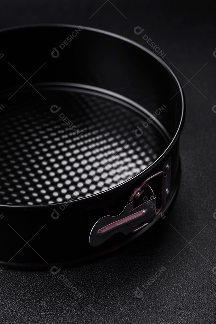 Assadeira destacável preta de metal redondo para assar em um fundo escuro de concreto