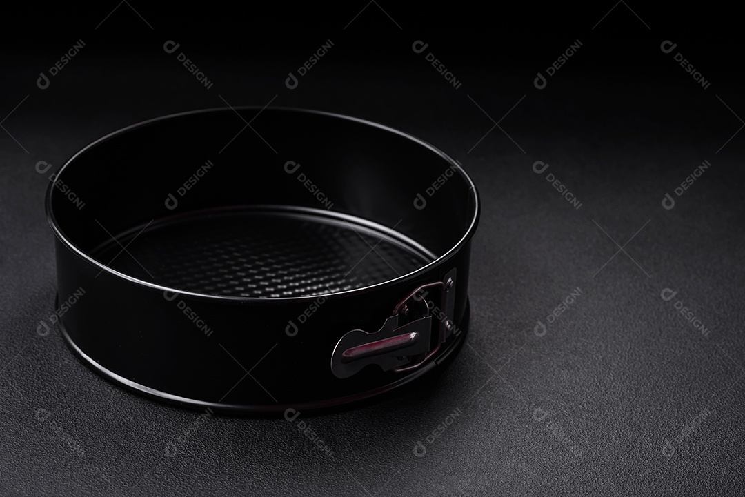 Assadeira destacável preta de metal redondo para assar em um fundo escuro de concreto