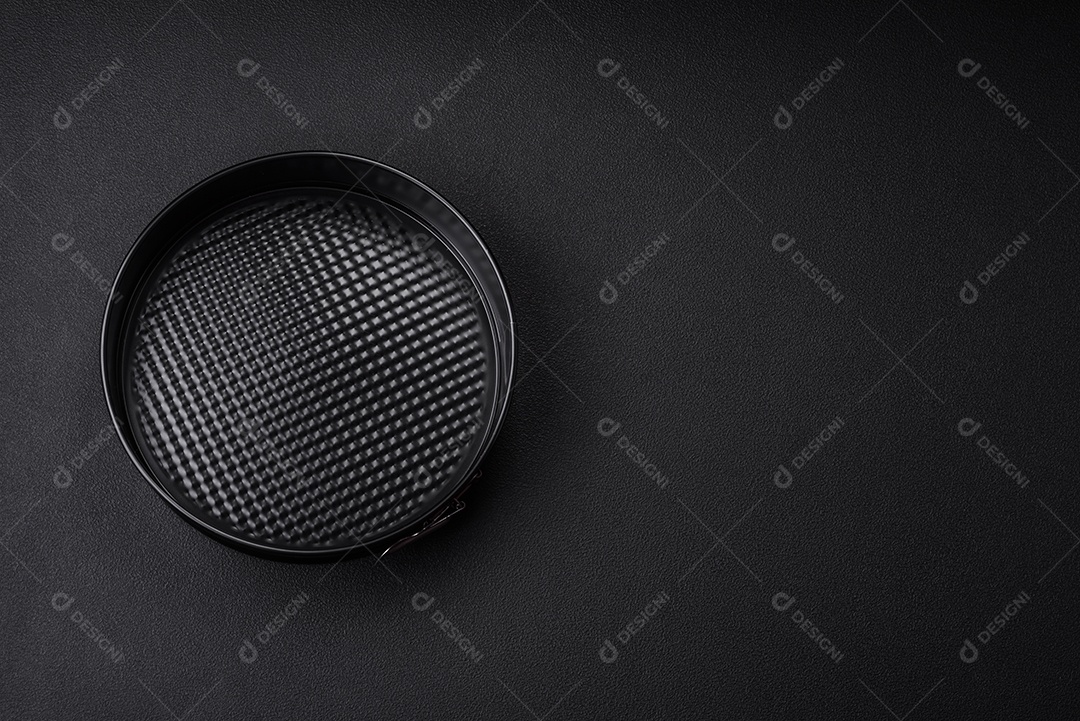 Assadeira destacável preta de metal redondo para assar em um fundo escuro de concreto