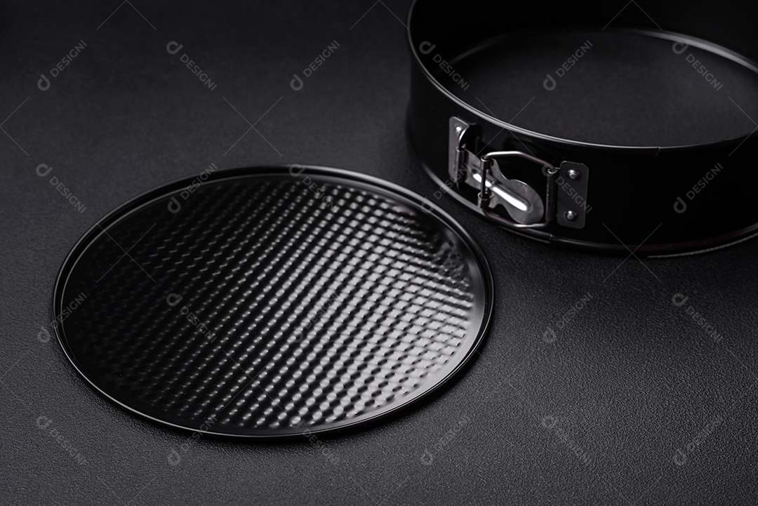 Assadeira destacável preta de metal redondo para assar em um fundo escuro de concreto