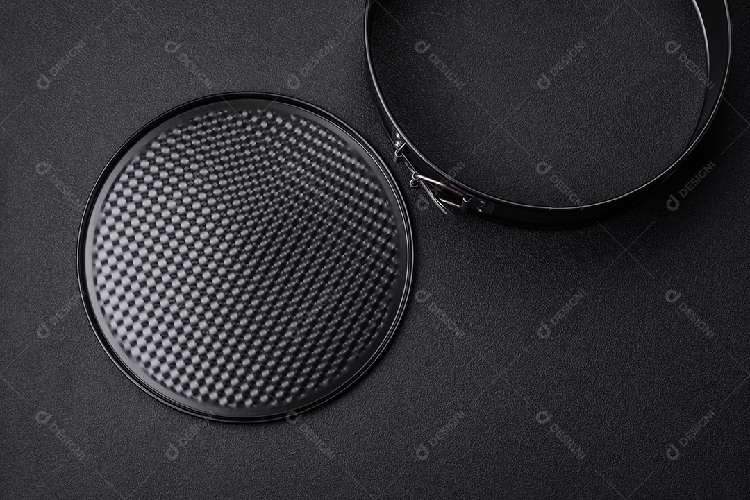 Assadeira destacável preta de metal redondo para assar em um fundo escuro de concreto