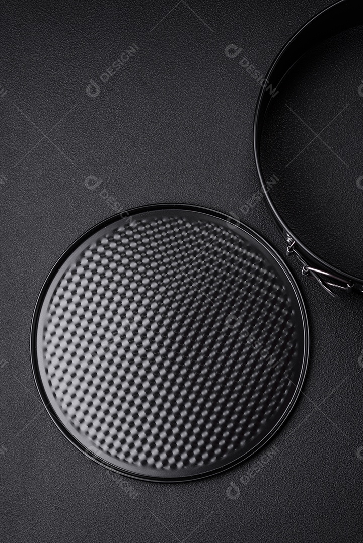 Assadeira destacável preta de metal redondo para assar em um fundo escuro de concreto
