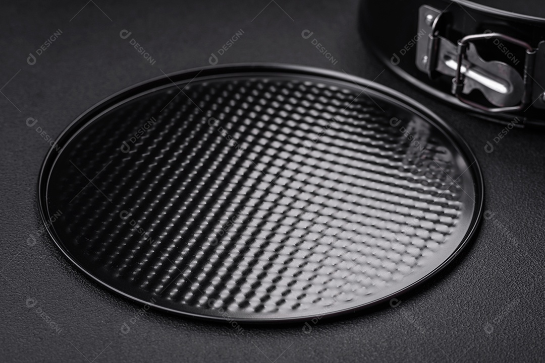 Assadeira destacável preta de metal redondo para assar em um fundo escuro de concreto