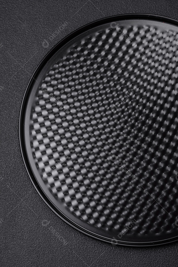 Assadeira destacável preta de metal redondo para assar em um fundo escuro de concreto