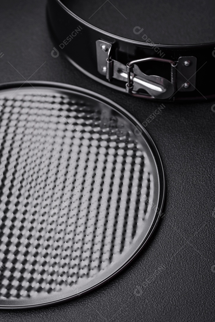 Assadeira destacável preta de metal redondo para assar em um fundo escuro de concreto