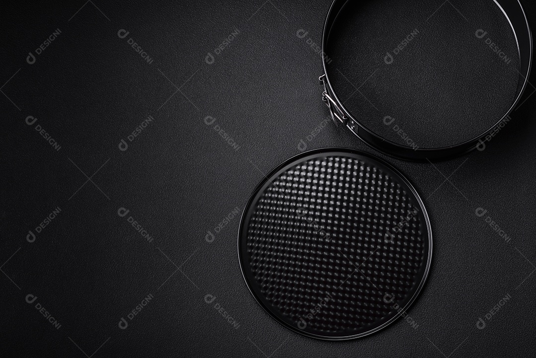 Assadeira destacável preta de metal redondo para assar em um fundo escuro de concreto