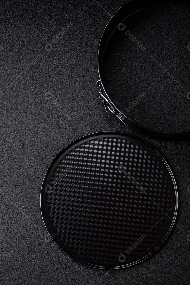 Assadeira destacável preta de metal redondo para assar em um fundo escuro de concreto