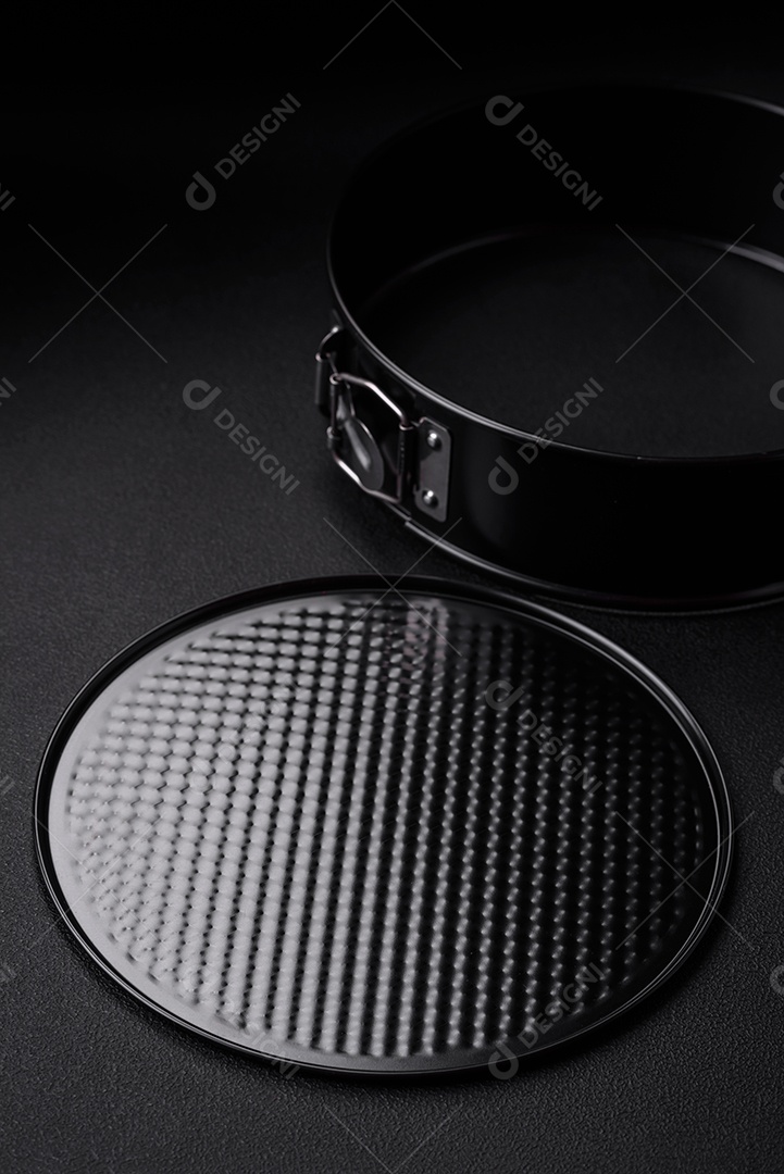 Assadeira destacável preta de metal redondo para assar em um fundo escuro de concreto