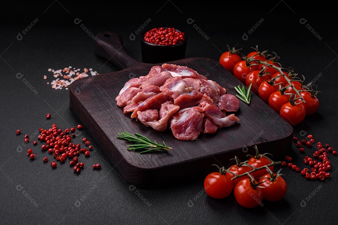 Corações crus de frango ou peru com sal, especiarias e ervas sobre um fundo de concreto texturizado