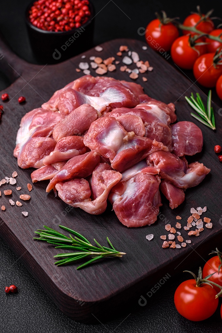 Corações crus de frango ou peru com sal, especiarias e ervas sobre um fundo de concreto texturizado