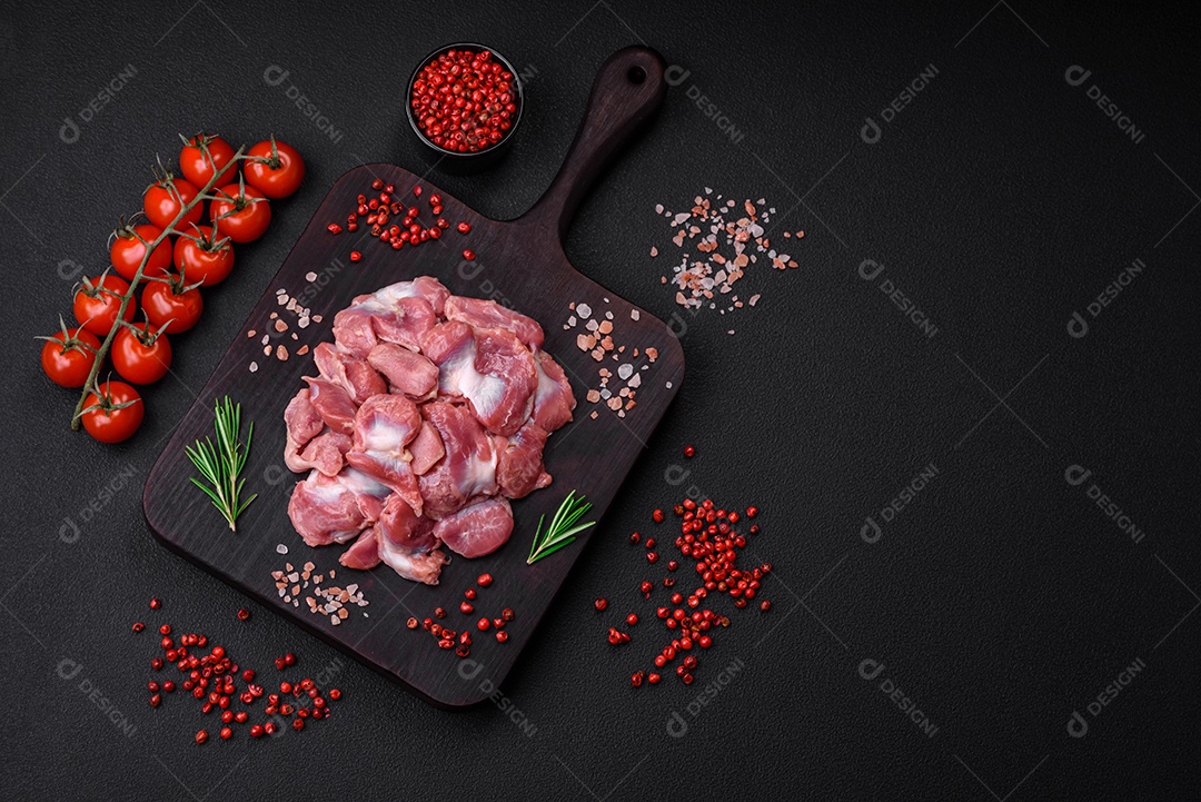 Corações crus de frango ou peru com sal, especiarias e ervas sobre um fundo de concreto texturizado