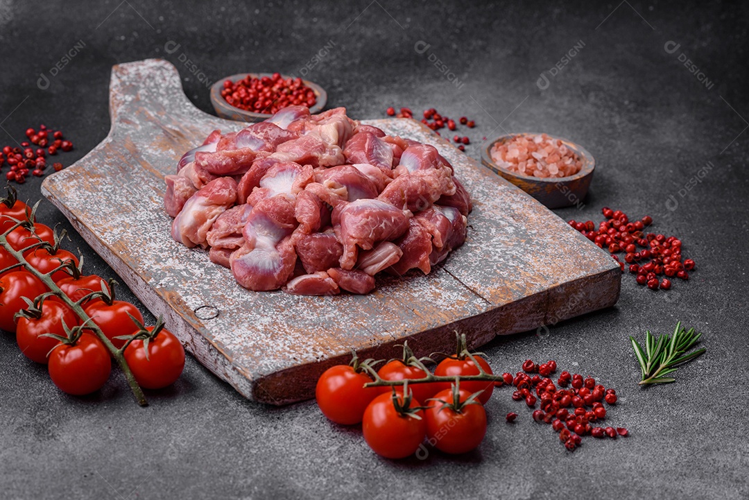 Corações crus de frango ou peru com sal, especiarias e ervas sobre um fundo de concreto texturizado