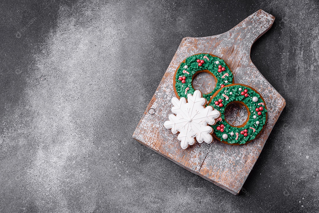 Deliciosos e lindos biscoitos de gengibre de Natal sobre um fundo de concreto texturizado como decoração para uma mesa festiva de Ano Novo