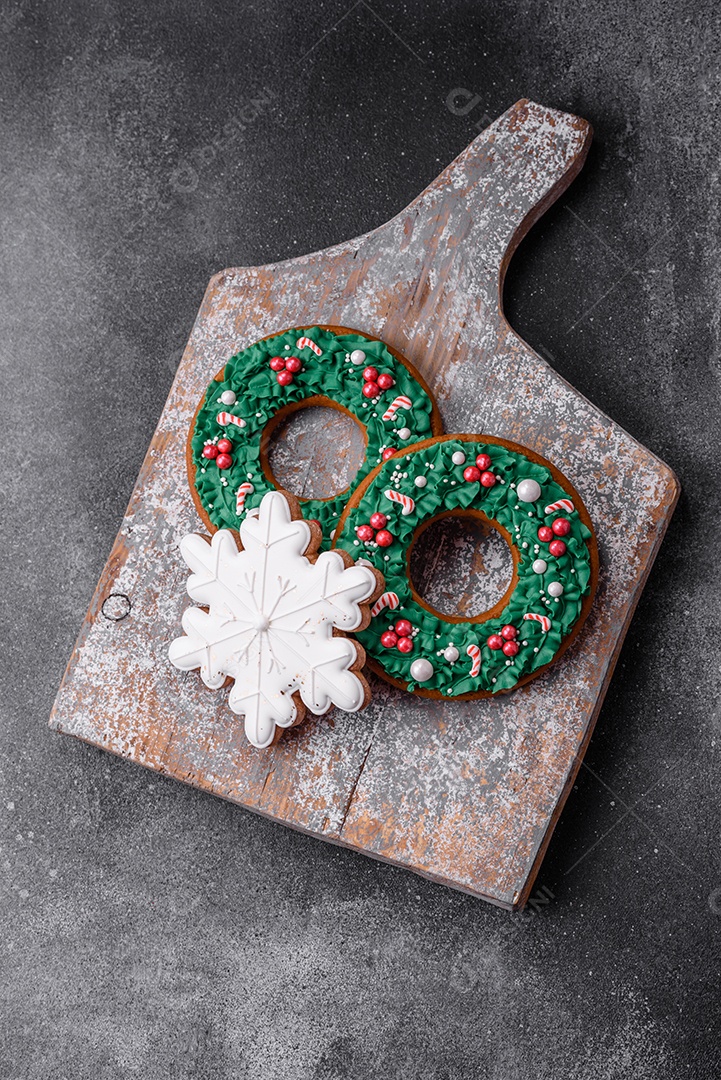 Deliciosos e lindos biscoitos de gengibre de Natal sobre um fundo de concreto texturizado como decoração para uma mesa festiva de Ano Novo