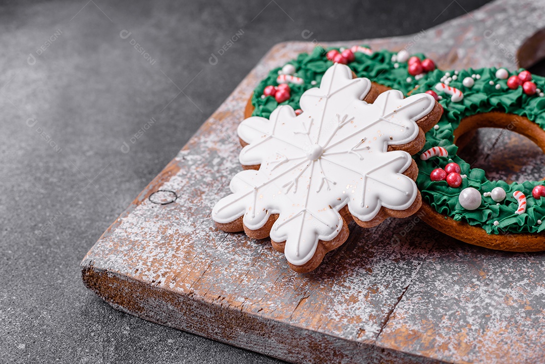 Deliciosos e lindos biscoitos de gengibre de Natal sobre um fundo de concreto texturizado como decoração para uma mesa festiva de Ano Novo