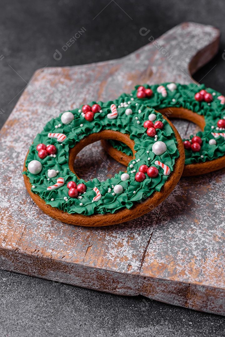 Deliciosos e lindos de gengibre de Natal sobre um fundo de concreto texturizado como decoração para uma mesa festiva de Ano Novo