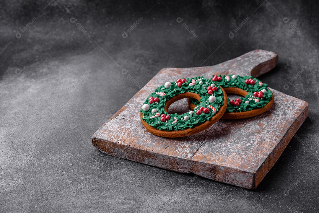 Deliciosos e lindos biscoitos de gengibre de Natal sobre um fundo de concreto texturizado como decoração para uma mesa festiva de Ano Novo