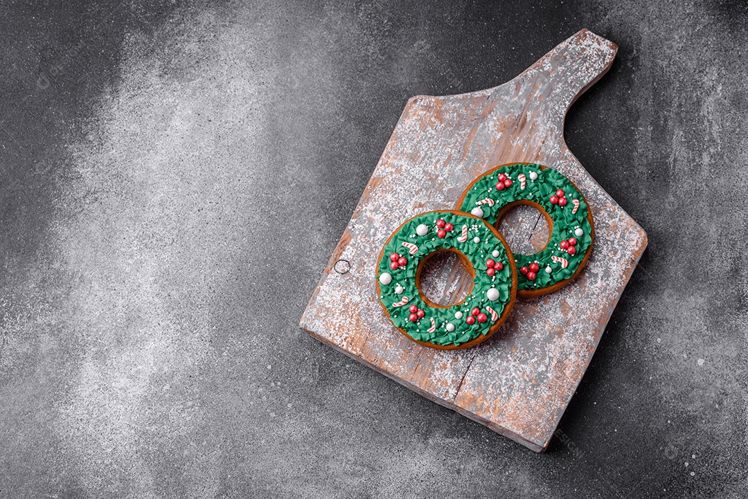 Deliciosos e lindos biscoitos de gengibre de Natal sobre um fundo de concreto texturizado como decoração para uma mesa festiva de Ano Novo