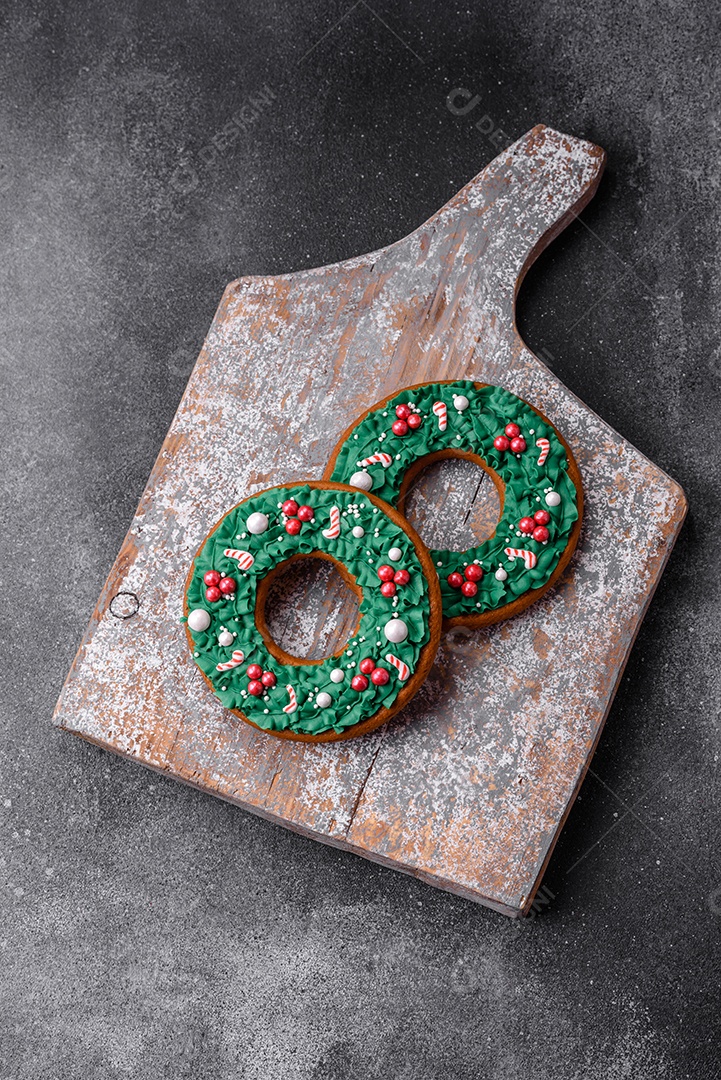 Deliciosos e lindos biscoitos de gengibre de Natal sobre um fundo de concreto texturizado como decoração para uma mesa festiva de Ano Novo