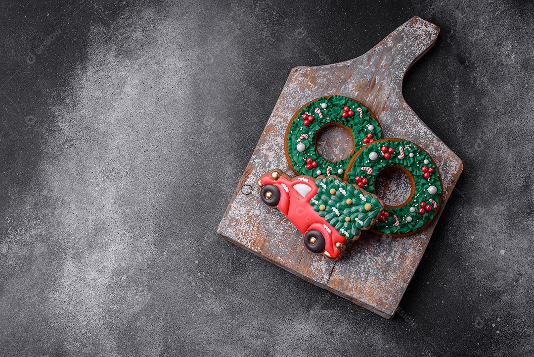 Deliciosos e lindos biscoitos de gengibre de Natal sobre um fundo de concreto texturizado como decoração para uma mesa festiva de Ano Novo