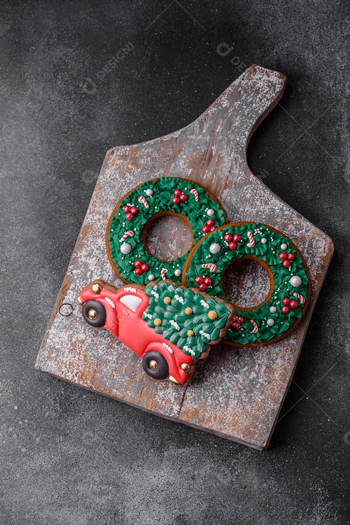 Deliciosos e lindos biscoitos de gengibre de Natal sobre um fundo de concreto texturizado como decoração para uma mesa festiva de Ano Novo