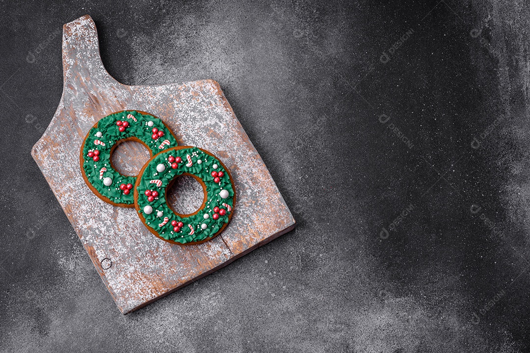 Deliciosos e lindos biscoitos de gengibre de Natal sobre um fundo de concreto texturizado como decoração para uma mesa festiva de Ano Novo