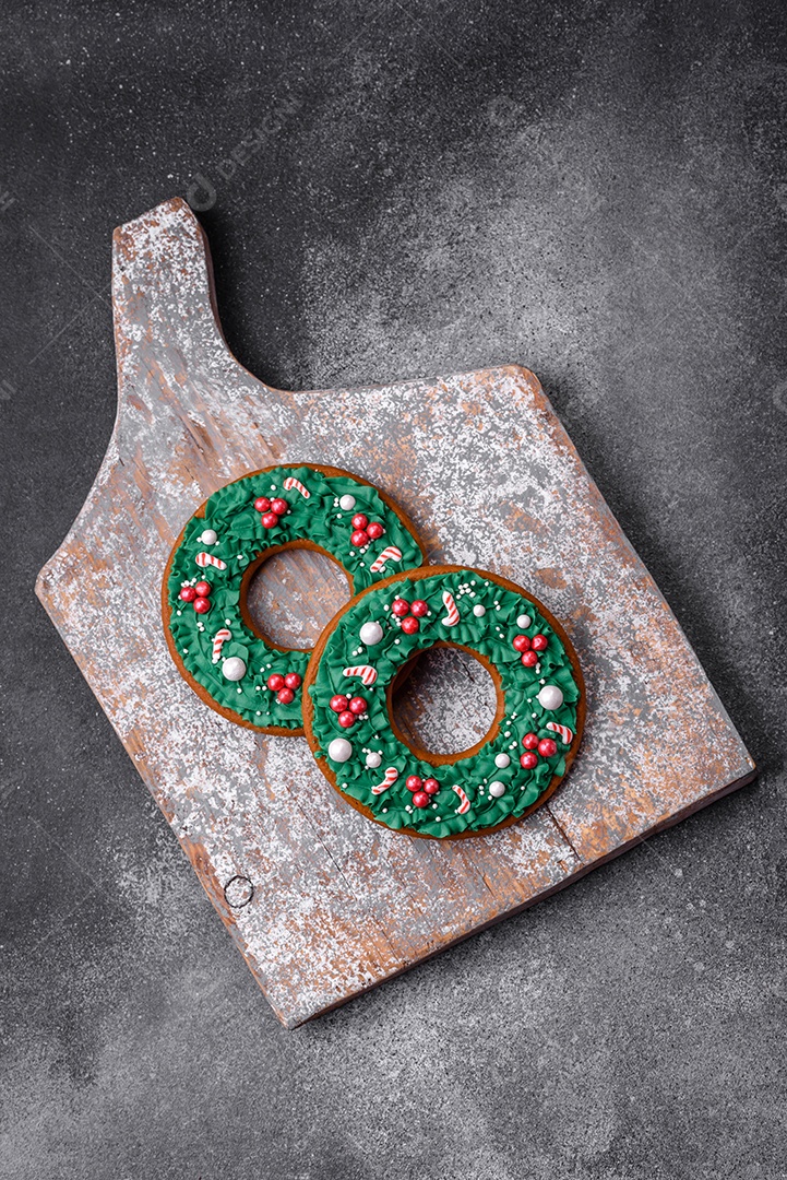 Deliciosos e lindos biscoitos de gengibre de Natal sobre um fundo de concreto texturizado como decoração para uma mesa festiva de Ano Novo