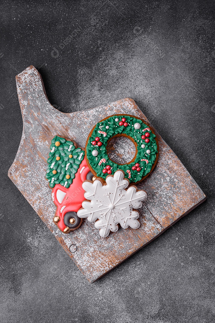 Deliciosos e lindos biscoitos de gengibre de Natal sobre um fundo de concreto texturizado como decoração para uma mesa festiva de Ano Novo