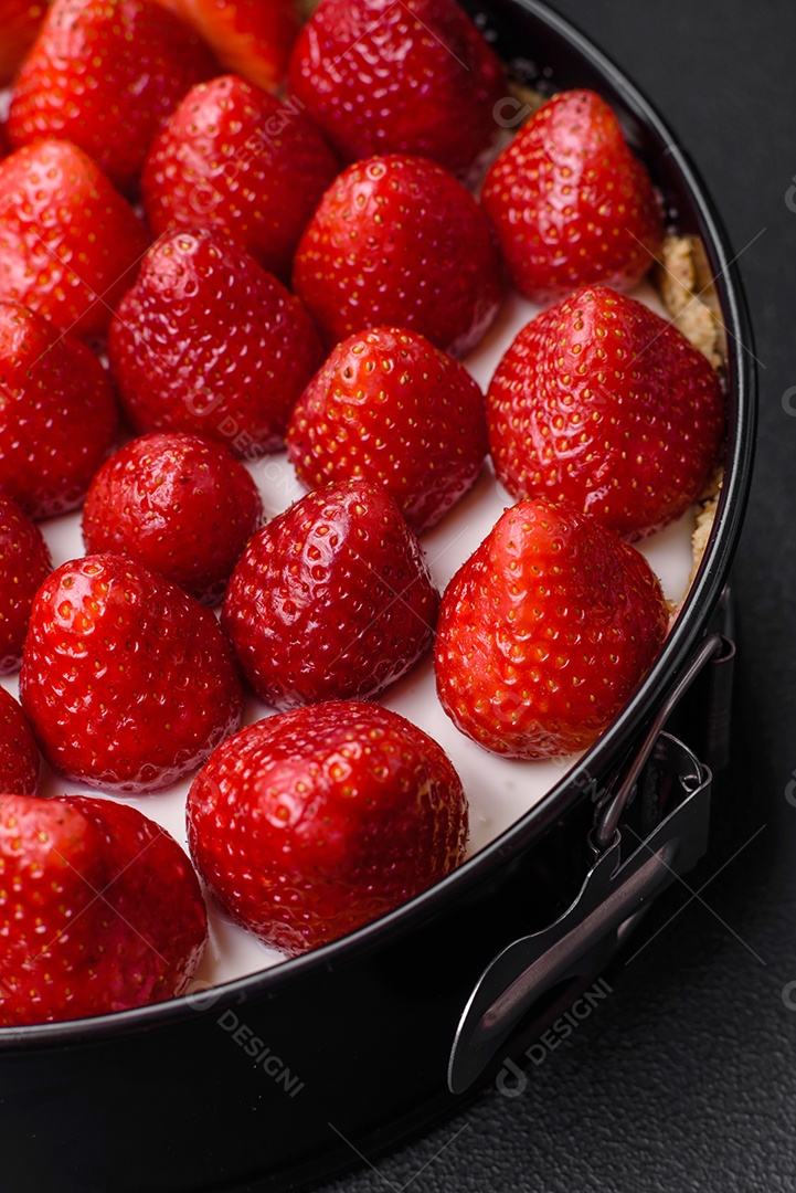 Delicioso bolo doce ou cheesecake com queijo mascarpone e morangos sobre um fundo escuro de concreto