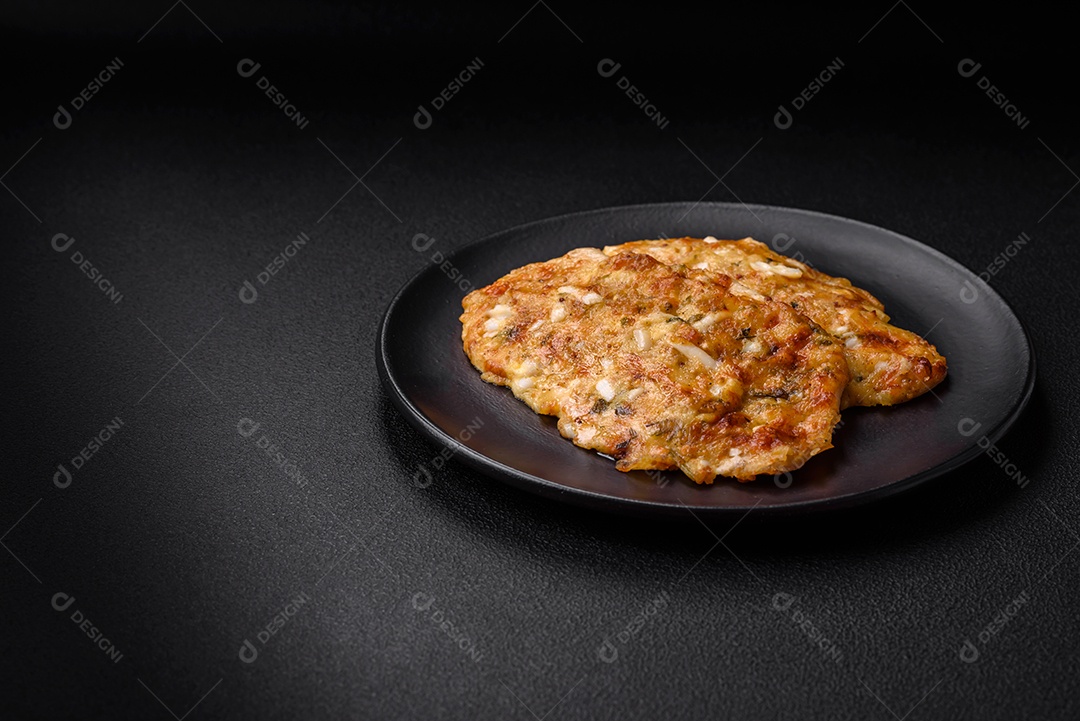 Delicioso peito de frango frito em massa com mostarda, sal, especiarias e queijo sobre fundo escuro de concreto