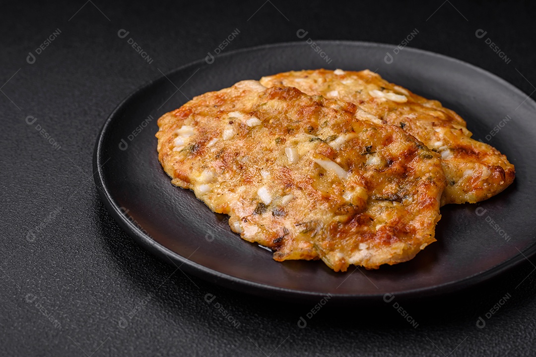 Delicioso peito de frango frito em massa com mostarda, sal, especiarias e queijo sobre fundo escuro de concreto
