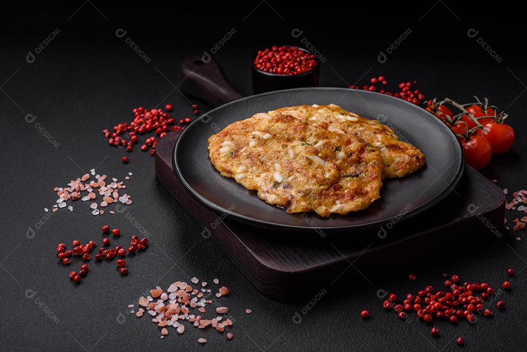 Delicioso peito de frango frito em massa com mostarda, sal, especiarias e queijo sobre fundo escuro de concreto