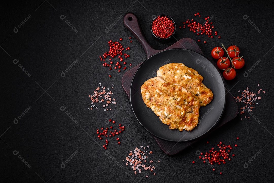 Delicioso peito de frango frito em massa com mostarda, sal, especiarias e queijo sobre fundo escuro de concreto