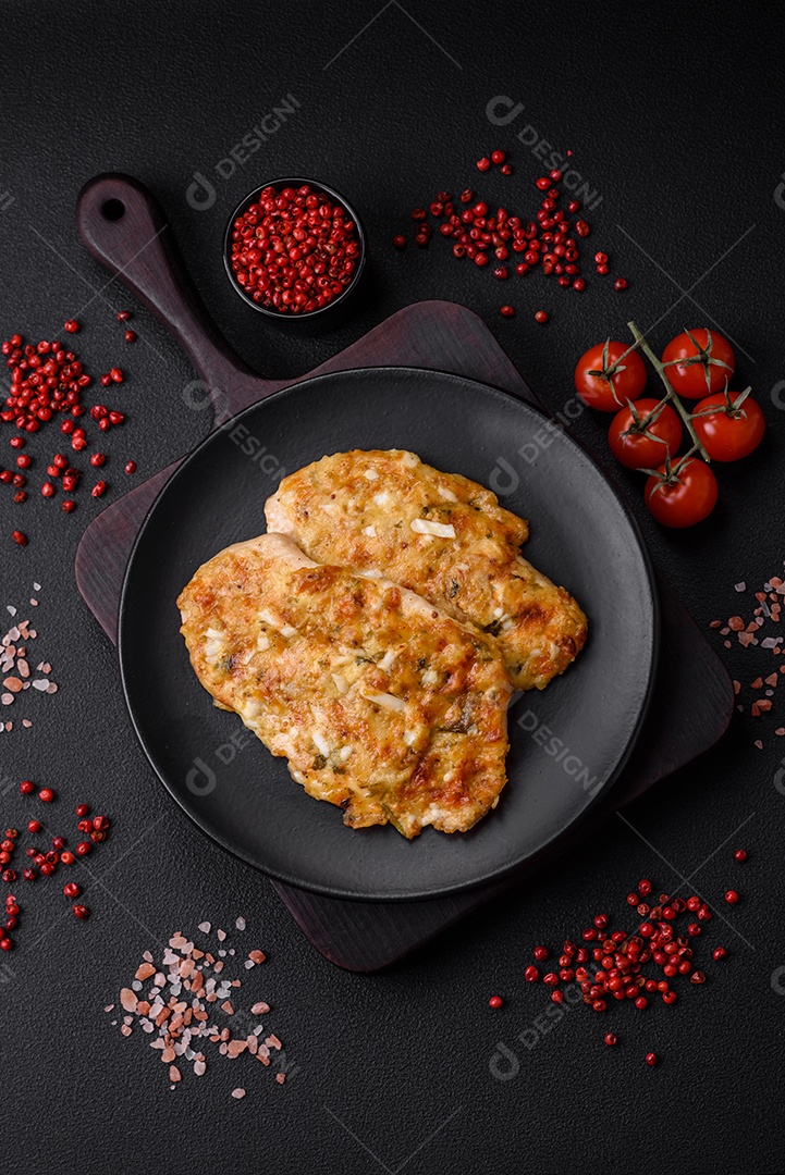 Delicioso peito de frango frito em massa com mostarda, sal, especiarias e queijo sobre fundo escuro de concreto